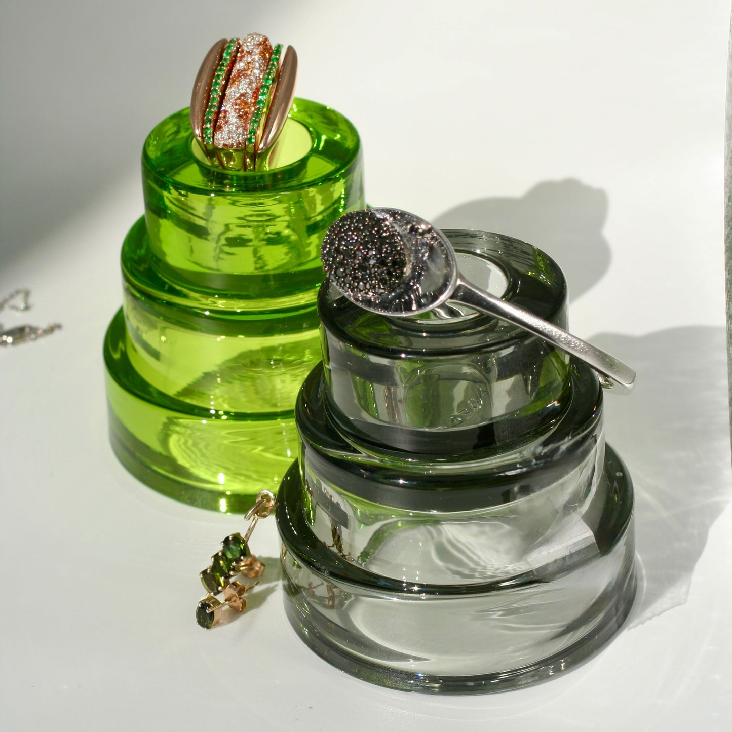 Lobster roll ring stack and caviar cuff and martini cocktail olive earrings on glass stands