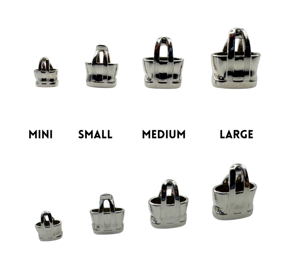 Set of silver handbag-shaped charms in different sizes on a white background